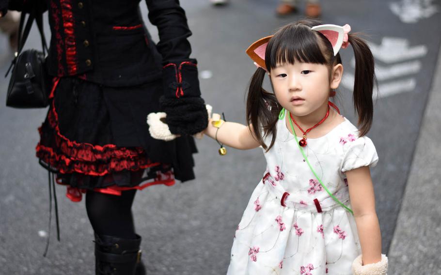 A girl marches in a parade during the Bakeneko festival, Sunday, Oct. 16, 2016, in Tokyo. The annual Halloween-like festival, whose name roughly translates to "ghost cat with supernatural powers," includes a parade of costumed revelers, live music and street dancing.
