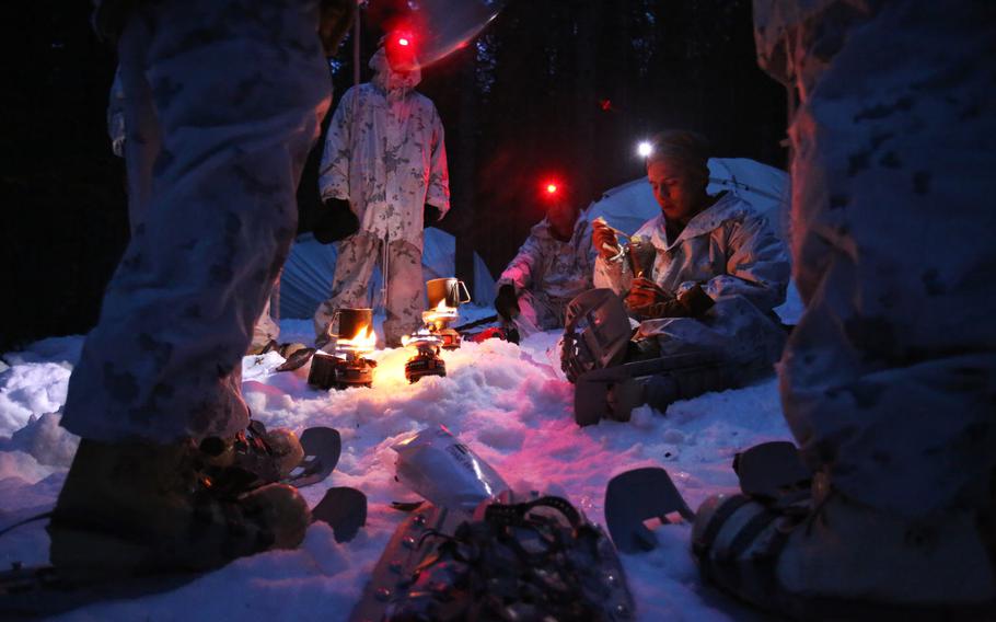 A group of U.S. Marines  assigned to The Combined Arms Company out of Bulgaria uses small burners to melt snow into water as the unit sets up camp for the night in Rena, Norway, Feb. 22, 2016.