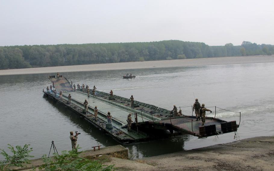A French-made motorized pontoon bridge is assembled on the Po River in northern Italy by Italian army engineers on Tuesday, Oct. 18, 2016, during an exercise with the 173rd Airborne Brigade.