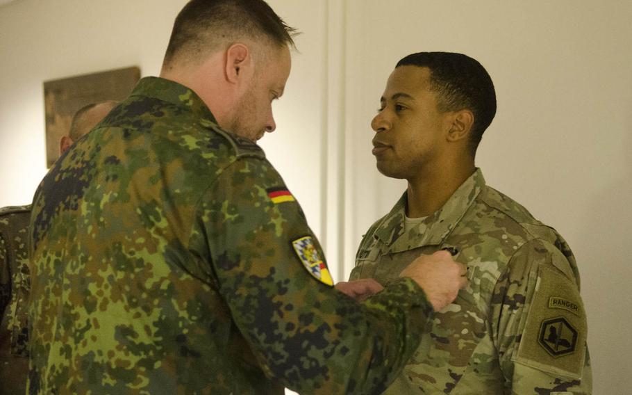 German Army Sgt. Maj. Juergen Schulz, left, of the Landeskommando Bayern, pins the German Armed Forces Badge for Military Proficiency on the uniform of Capt. Dougal Hutton of the 66th Military Intelligence Brigade, Thursday, Oct. 20, 2016, at Clay Kaserne in Wiesbaden, Germany. Schulz and three other German soldiers administered testing for the badge, which covered three days and six physically and mentally challenging events.