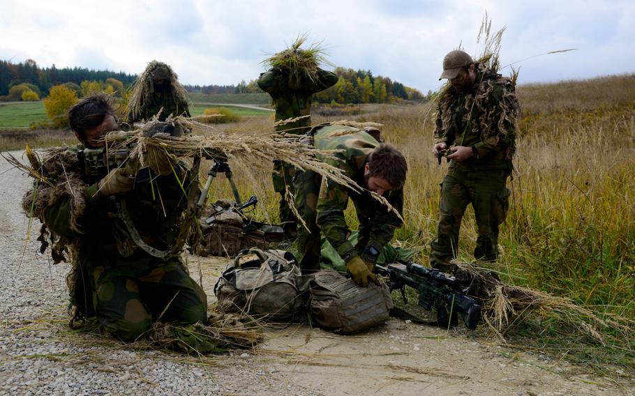 Norwegian soldiers use nearby grass to adjust their ghillie suits and camouflage their weapons before taking part in the stalking challenge of the European Best Sniper Squad Competition at the 7th Army Training Command?s, Grafenwoehr Training Area in Germany on Wednesday, Oct. 26, 2016. The Norwegian squad took first place in the four-day contest.