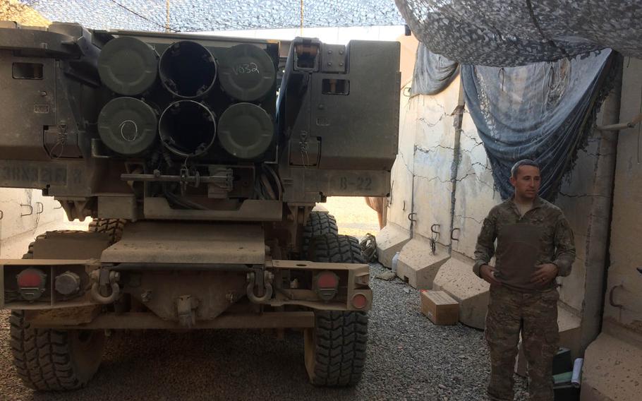 Army Staff Sgt. Thomas Morris, 34, of Abingdon, Md.,stands next to a pair of HIMARS rocket launchers on Saturday, Oct. 29, 2016, at Qayara Airfield West in northern Iraq.