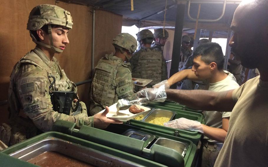 Troops get chow from a field kitchen at Qayara Airfield West on Saturday, Oct. 29, 2016.