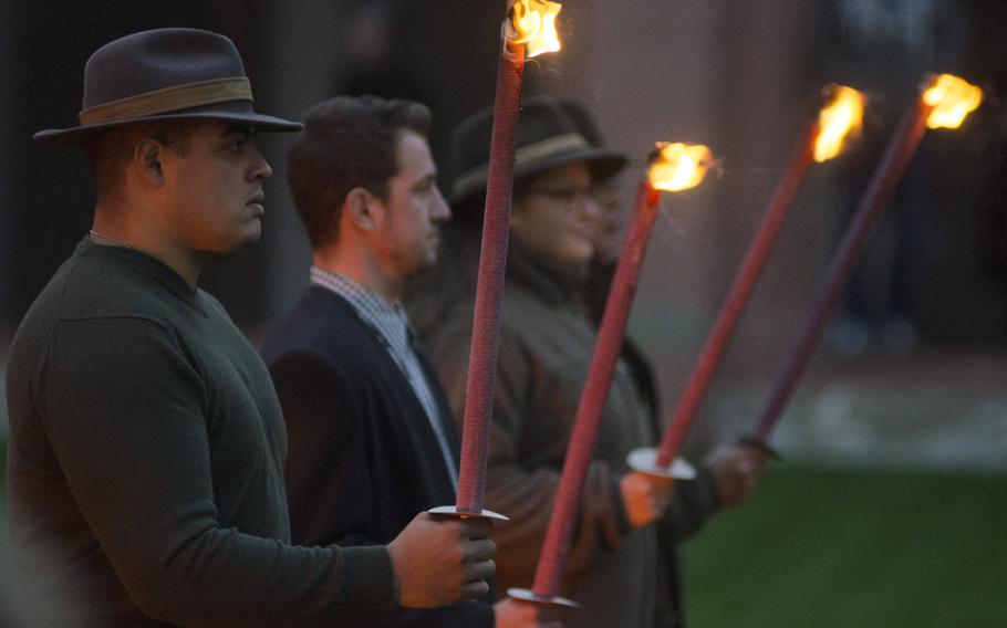 Torchbearers stand during a Jaegerschlag, or hunter induction, ceremony at Eberbach Abbey near Eltville, Sunday, Oct. 30, 2016. The ceremony is always conducted by torchlight, and torchbearers are either current hunters or family members of those being inducted. Eighteen Americans were inducted into the German hunting community in Sunday's ceremony, earning their Jagdschein, or hunting license.