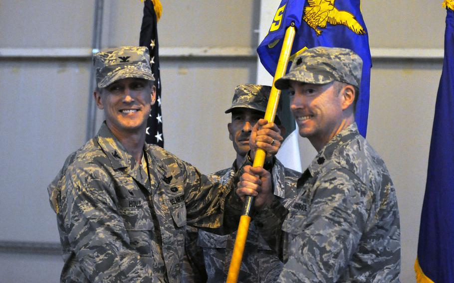 Col. Craig Hollis, commander of the 31st Operations Group, left, and  Lt. Col. Aaron Gibney, commander of the 606th Air Control Squadron hold the guidon while Master Sgt. Andrew Horton looks on during the activation ceremony for the 606th at Aviano Air Base, Italy, on Tuesday, Nov. 1, 2016.