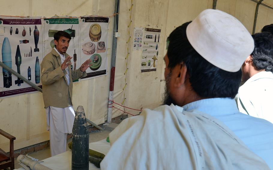 A worker at the Samarkhel Encashment Center outside Jalalabad, Afghanistan, instructs returning refugees in mine awareness on Thursday, Oct. 6, 2016. Thousands of Afghans repatriating from Pakistan are being vaccinated and given cash grants at the center operated by the U.N. and the Afghan government.