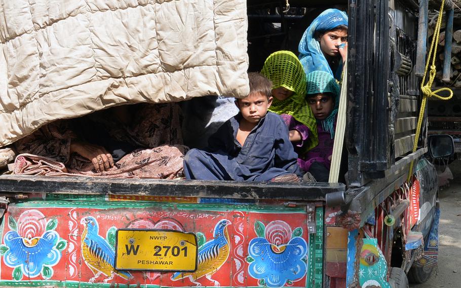 Afghan refugees in a colorful Pakistani truck wait outside the Samarkhel Encashment Center in Jalalabad, Afghanistan, on Thursday, Oct. 6, 2016. Returning refugees register at the center, where they receive financial, legal, administrative and medical aid.