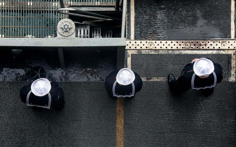 Sailors man the rails on the flight deck of the USS Ronald Reagan as the ship pulls into Busan, South Korea, for a port visit, Oct. 16, 2016. The Navy has issued preliminary guidance for issues arising from sailors seeking gender transition, noting that no changes will made to the service's physical readiness program for those individuals.
