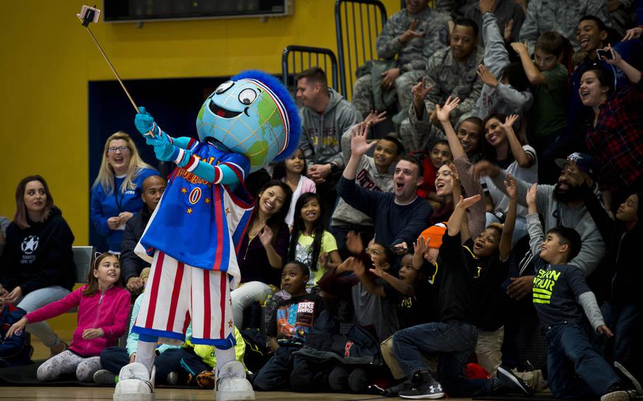 Globie, the Harlem Globetrotters mascot, takes a selfie with spectators before a show at Ramstein Air Base, Germany, on Thursday, Nov. 10, 2016.