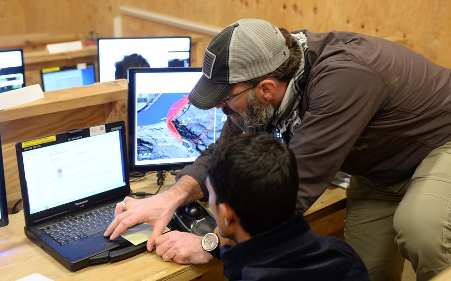 ScanEagle instructor Chris Schoenen helps a student who is training to become a surveillance drone pilots at a school outside the city of Mazar-e-Sharif on Wednesday, Oct. 26, 2016.
