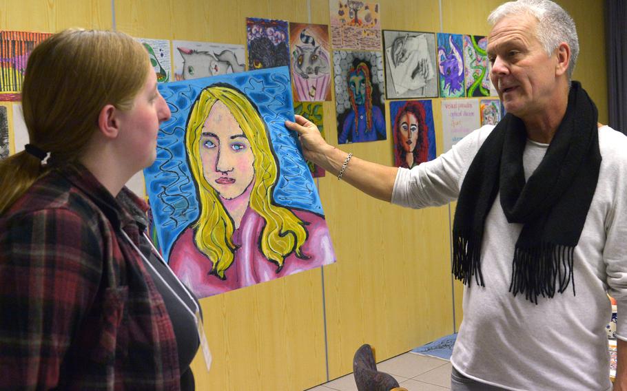Emily Gilbert of Vicenza discusses her portrait with instructor Wade Krauchi in the drawing workshop at Creative Connections, an annual weeklong DODEA-Europe performing and visual arts symposium for high school students.