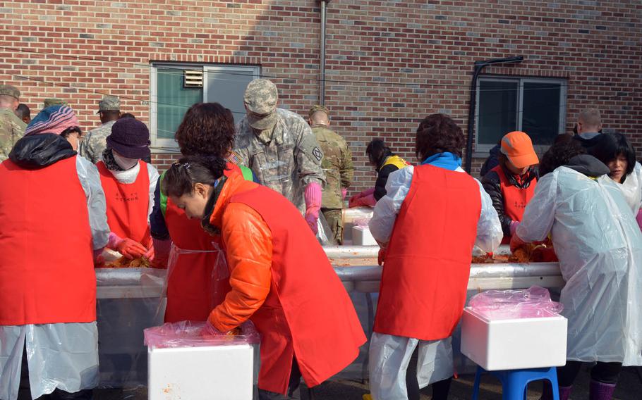 South Koreans teach U.S. soldiers with the 210th Field Artillery Brigade how to make kimchi, Thursday, Nov. 17, 2016, at a volunteer center in Dongducheon, South Korea. The 40 soldiers from the Fort Sills, Okla.-based 2-18 Field Artillery Battalion rotated into South Korea last month to join the 210th Field Artillery Brigade, which is stationed near the border with North Korea.