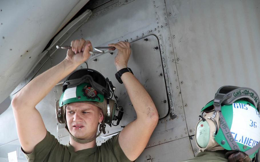 Lance Cpl. Taegen Todd Duncan, a Marine Aircraft Group 36 MV-22 Osprey mechanic from Oklahoma, opens a panel on one of the tilt-rotor aircraft while performing maintenance at Marine Corps Air Station Futenma, Okinawa, Nov. 3, 2016.
