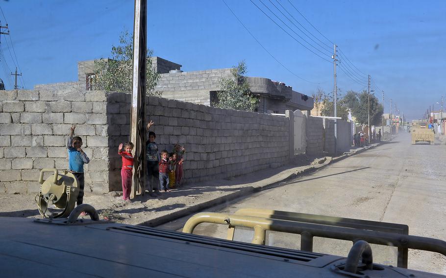 Children in the Intisar neighborhood of Mosul greet passing Iraqi army Humvees with cheers and victory signs on Saturday, Nov. 19, 2016. Though an indicator that the area has been cleared of Islamic State fighters, the outbursts are no guarantee that militants aren't concealing themselves among the civilian population.
