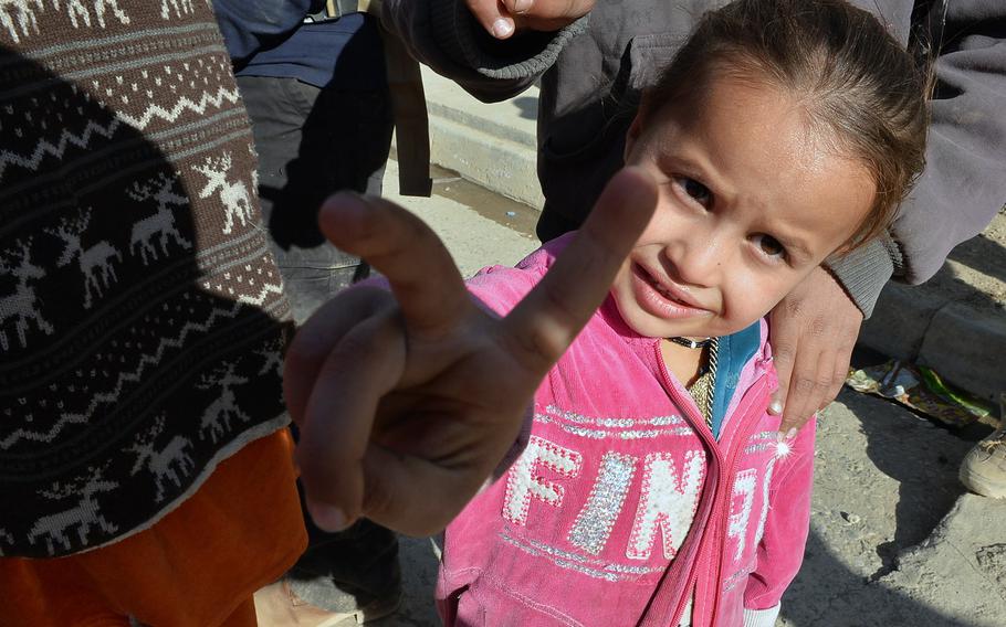 A young Iraqi girl in the Intisar neighborhood of Mosul flashes a victory sign on Saturday, Nov. 19, 2016.