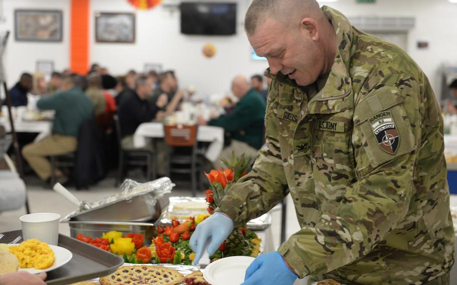 Army Col. Thomas Gukeisen serves dessert to those celebrating Thanksgiving at NATO's Resolute Support headquarters in Kabul, Afghanistan, on Thursday, Nov. 24, 2016.