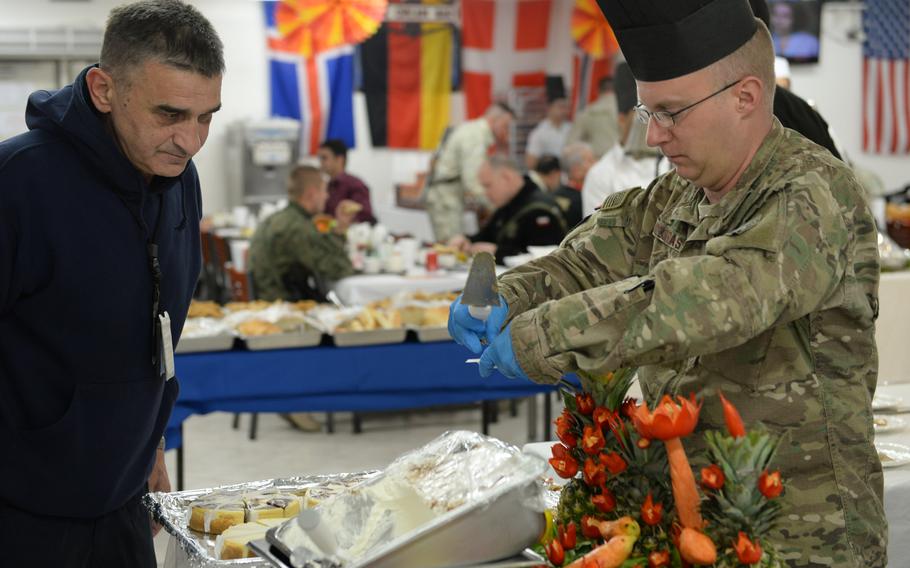 Air Force Col. Nick Kozdras serves dessert during Thanksgiving celebrations at Resolute Support headquarters in Kabul, Afghanistan, on Thursday, Nov. 24, 2016.