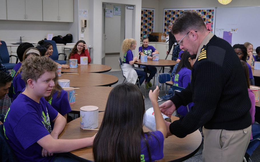 USS Shiloh commanding officer Capt. Adam Aycock examines Civil War-style drums Yokosuka Middle School students made as a part of a history project Dec. 13, 2016.