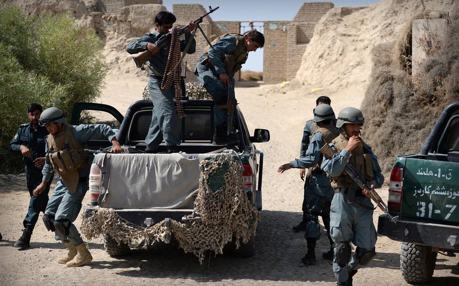 Afghan policemen dismount from a truck during a patrol in Helmand province on Sept. 23, 2014. An Afghan official said Tuesday that an Afghan policeman killed 11 colleagues Monday night before fleeing the scene.