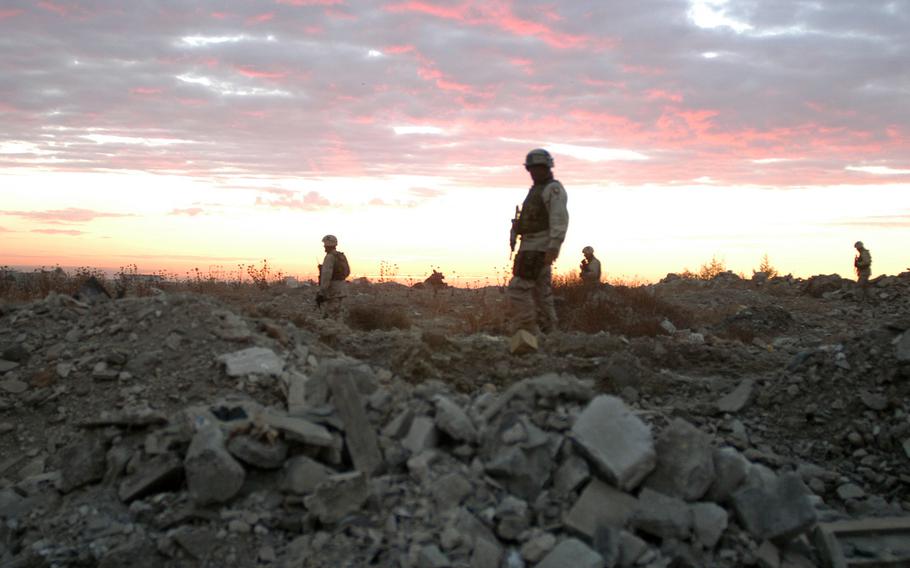 Mortar platoon soldiers based at Camp Widowmaker in Mosul, Iraq, search for bombs at sunrise Nov. 21, 2003. The mortarmen were with the Headquarters and Headquarters Company, 3rd Battalion, 2nd Brigade Combat Team, 502nd Infantry Regiment, based in Fort Campbell, Ky.