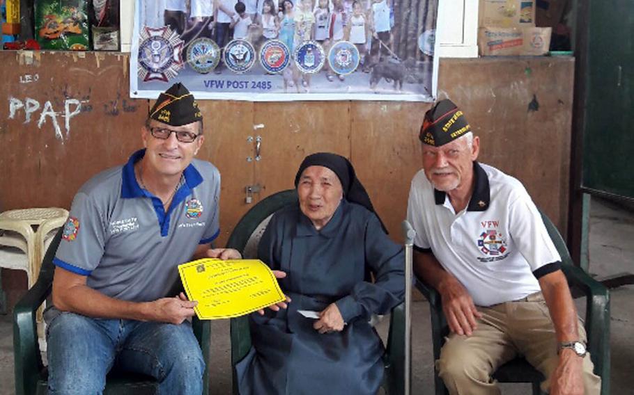 Norme Smith, left, Veterans of Foreign Wars Post 2485 commander, and John Gilbert, Department of the Pacific commander, present sister Alessandria Casas with $5,000 to help build an orphanage near Clark Air Base, Philippines.