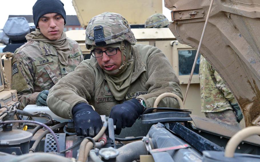 Spc. Jose Ayala, left, watches Sgt. Kevin Gutierrez make adjustments on a Humvee, near Bergen, Germany, after driving from Bremerhaven on their way to Poland, on Monday, Jan. 9, 2017. Both soldiers are with 1st Battalion, 8th Infantry Regiment, 3rd Armor Brigade Combat Team, 4th Infantry Division.