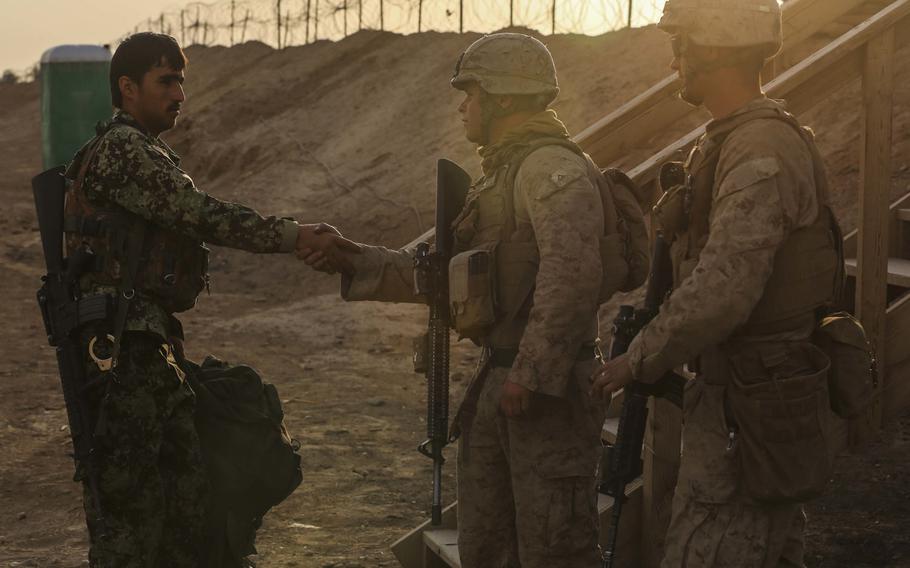 U.S. Marines with Alpha Company, 1st Battalion, 2d Marine Regiment, greet a member of the Afghanistan National Army as he takes post at Camp Leatherneck, Helmand province, Afghanistan, Oct. 27, 2014. The battalion was the final Marine Corps infantry battalion to serve in Helmand province as the Marine Corps turned over operations to the ANA.