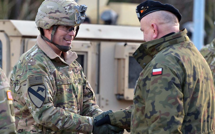 Polish Maj. Gen. Jaroslaw Mika, right, commander, 11th Armoured Cavalry Division, greets Col. Christopher Norrie,3rd Armored Brigade Combat Team, 4th Infantry Division commander, after a convoy of the unit's vehicles crossed the German-Polish border at the Olszyna crossing, Thursday, Jan. 12, 2017.