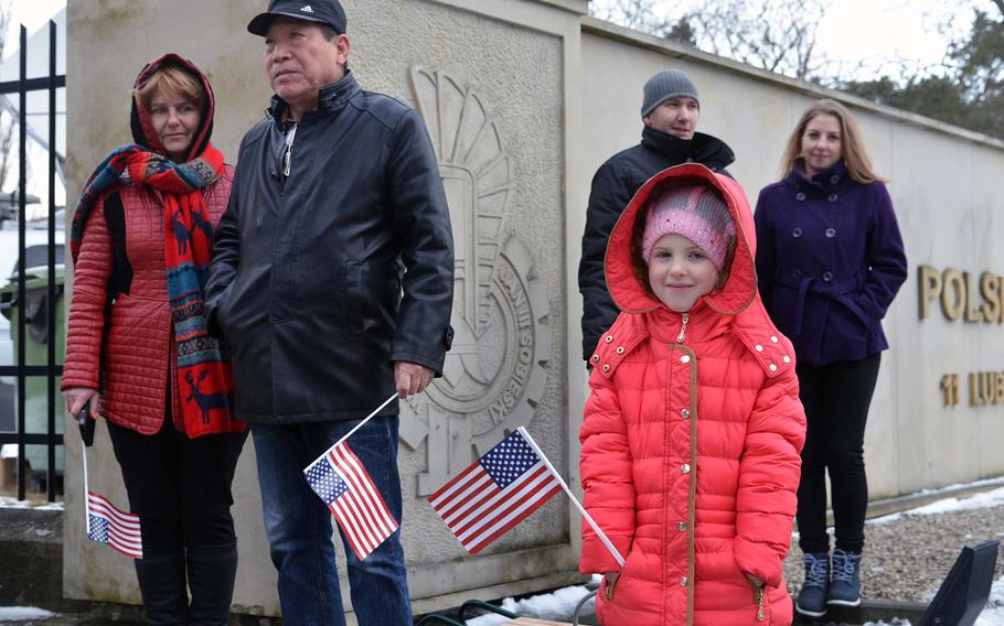 Spectators hold American flags during a welcoming ceremony for soldiers of the 3rd Armored Brigade Combat Team, 4th Infantry Division, in Zagan, Poland, Thursday, Jan. 12, 2017.