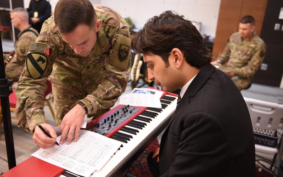 1st Lt. Philip Tappan of the U.S. Forces Afghanistan Band gives direction to Ghafar Maliknezhad, an assistant music professor at Kabul University, during a rehearsal for a joint concert with the band and university students and instructors, Wednesday, Jan. 25, 2017.