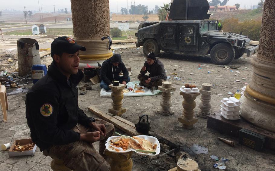 Iraqi troops eat lunch behind a palace in Mosul, Iraq, on Wednesday, Jan. 25, 2017.