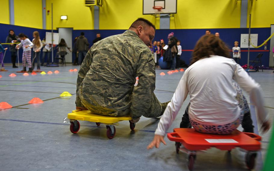 Air Force Master Sgt. Keith Beloso races his daughter, Kennedy Beloso, in the scooter relays at a family wellness night Thursday, Jan. 26, 2017, at Landstuhl Elementary/Middle School in Landstuhl, Germany.