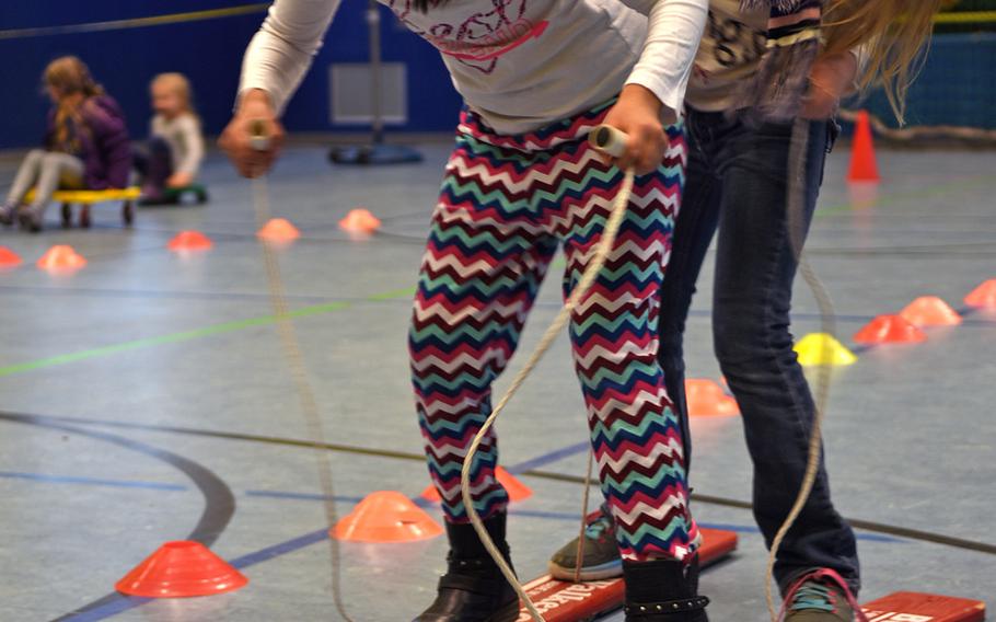 Natalia Paddlety, front, and Samantha Vasseur, try to walk together on buddy boards at a family wellness night on Thursday, Jan. 26, 2017, at Landstuhl Elementary/Middle School in Landstuhl, Germany.