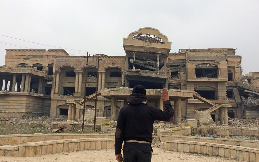 Iraqi special forces Capt. Aysar Ahmed Hassan, 36, poses in front of the wreck of a palace that was once U.S. Gen. David Petraeus' headquarters in Mosul, Iraq, on Friday, Jan. 27, 2017. On Independence Day, 2003, then Maj. Gen. David H. Petraeus, commander, 101st Airborne Division (Air Assault), administered the oath of reenlistment to more than 160 Screaming Eagle soldiers in front of the palace.