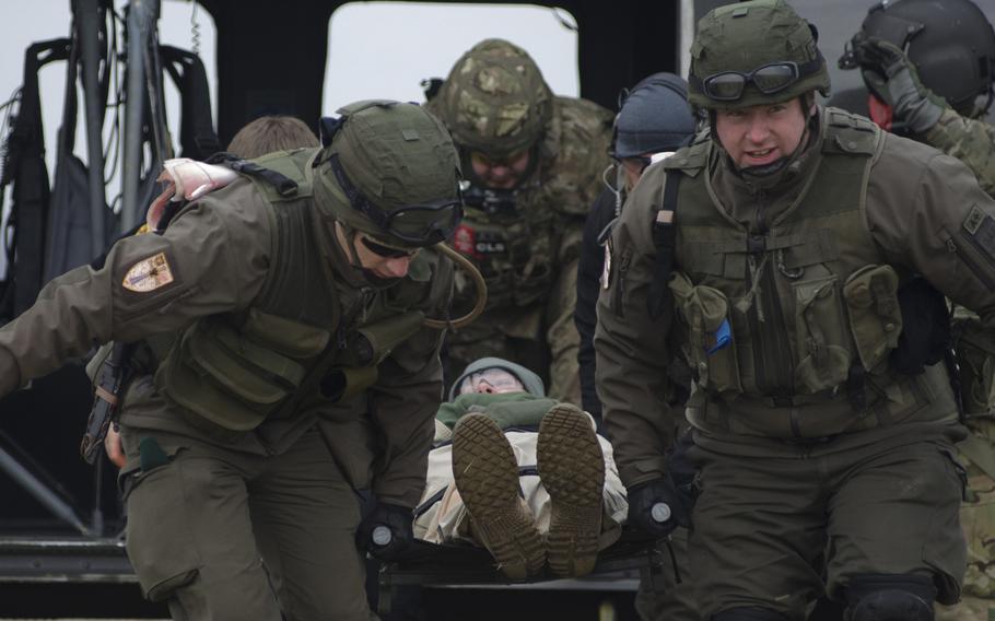 Austrian and U.S. soldiers unload a stretcher-borne casualty from a UH-60 Blackhawk helicopter during an international combat lifesaver course Thursday, Feb. 2, 2017, at Clay Kaserne in Wiesbaden, Germany.