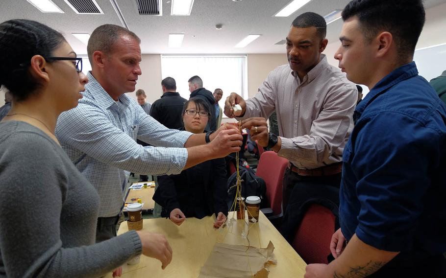 Sailors try to build a structure made of marshmallows and spaghetti during an innovation workshop at Yokosuka Naval Base, Japan, Friday, Jan. 24, 2017.