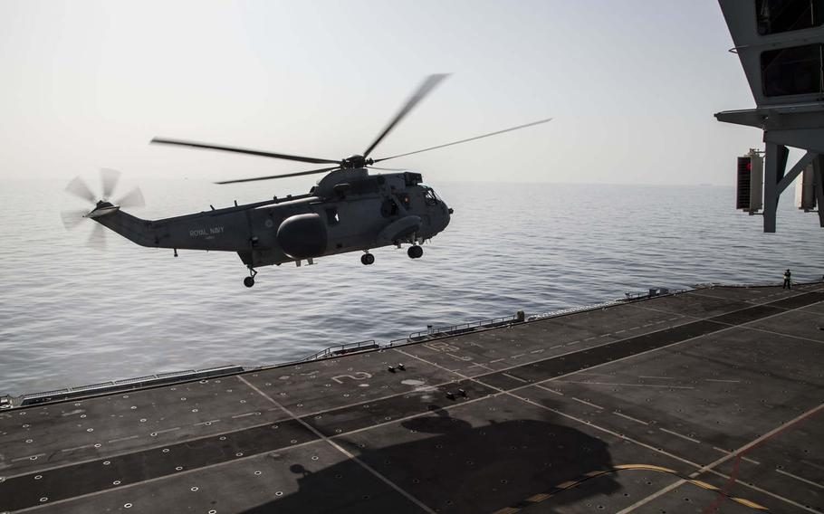 A helicopter takes off from the British navy's helicopter carrier HMS Ocean during exercise Unified Trident in the Persian Gulf, Jan. 31, 2016.