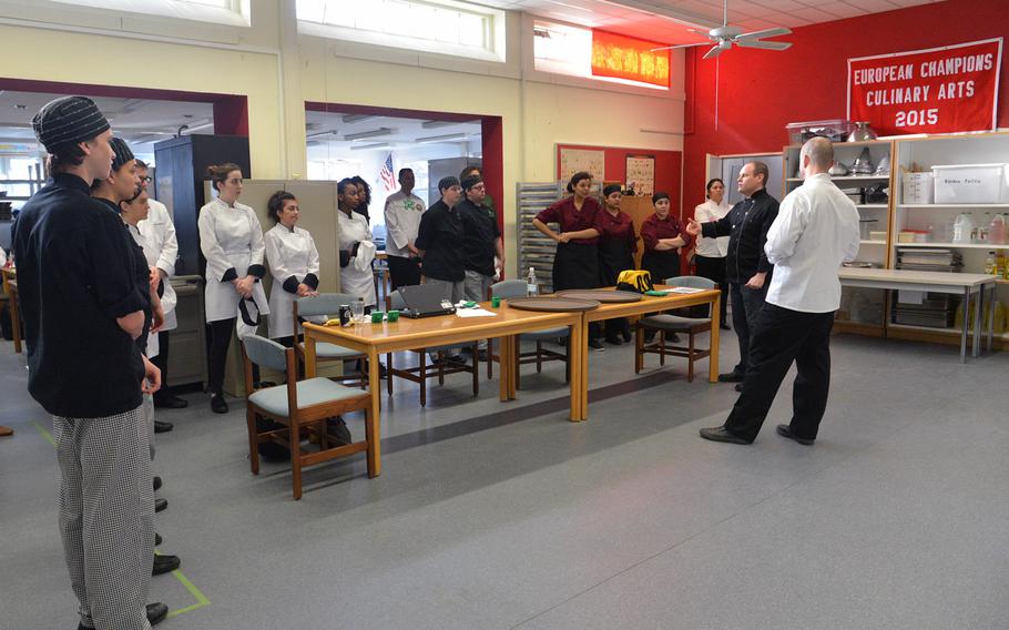 Andrew Dager, second from right, Kaiserslautern High School's culinary arts teacher and host, judge and cooridinator at the DODEA-Europe Culinary Arts Championships, welcomes and instructs the teams before the competition begins at Kaiserslautern High School, Wednesday, Feb. 15, 2017l.