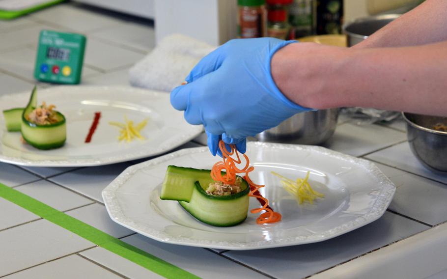 Nicholas Sherer of the Naples team put the finishing touches on their crab cucumber canape appetizer at the DODEA-Europe Culinary Arts Championships in Kaiserslautern, Germany, Wednesday, Feb. 15, 2017.