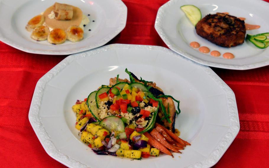 Wiesbaden's winning menu of honey sriacha orange chicken, foreground, Caribbean crepes desert, left, and a crab cake appetizer at the DODEA-Europe Culinary Arts Championships in Kaiserslautern, Germany, Wednesday, Feb. 15, 2017.