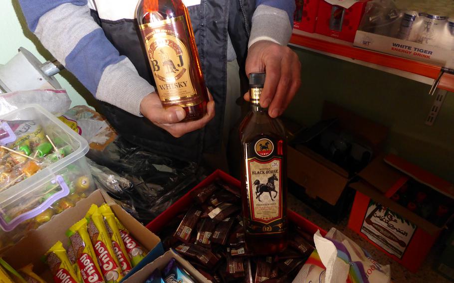 Khiri Elias shows off Black Jack and Black Horse whiskey bottles that he sells from a small shop in Bashiqa, Iraq, Monday, March 6, 2017. The village, known as "little Iraq" because its diverse population is a microcosm of the country, was liberated from roughly 2 1/2 years of Islamic State occupation in November and is slowly coming back to life.
