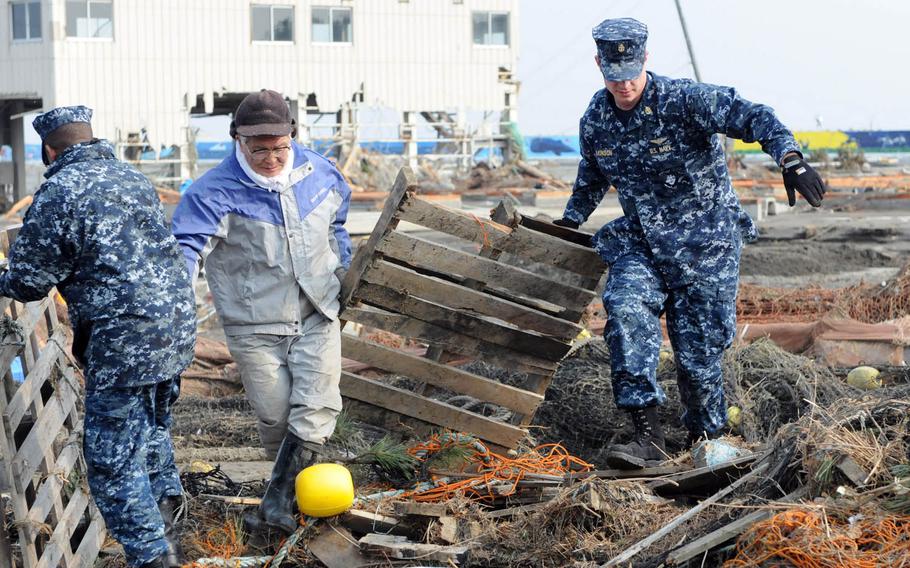 Sailors assigned to Naval Air Facility Misawa, Japan, help remove debris during a cleanup effort at the Misawa Fishing Port, March 14, 2011. More than 90 sailors volunteered to help clean up after an earthquake and tsunami.