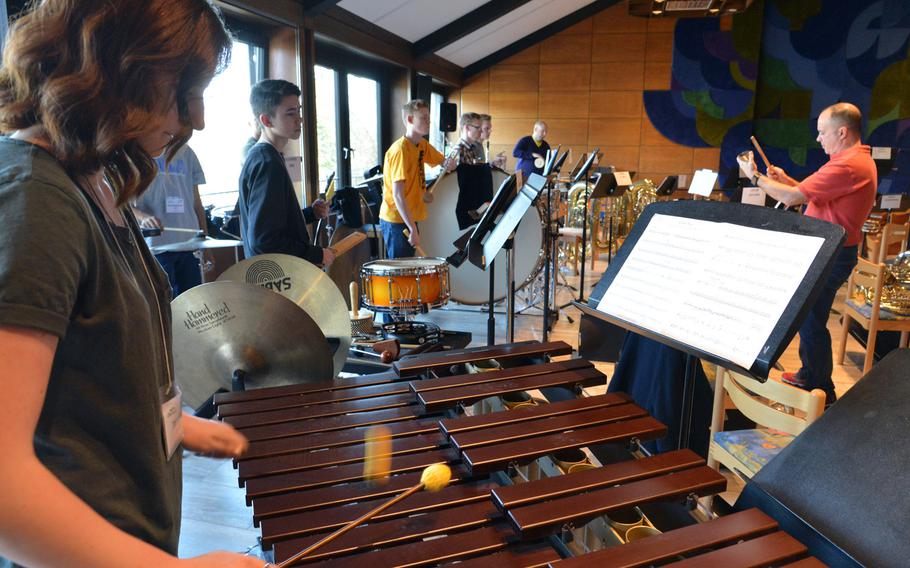 AFNORTH's Taylor Haddox mans the mallets as she and the rest of the percussion section go through a number with conductor Don Schofield Jr., right, as they rehearse at the DODEA-Europe Honors Music Festival, Tuesday, March 14, 2017.