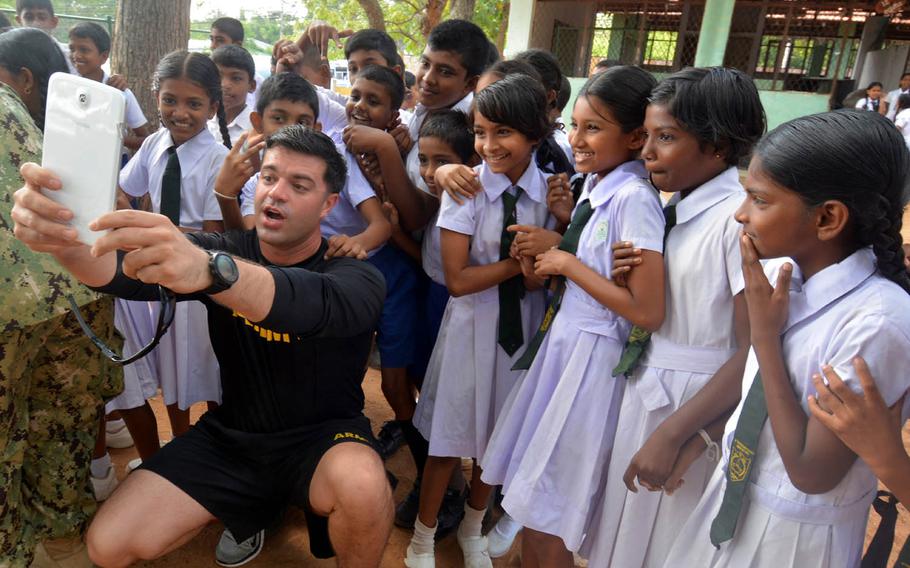 Sgt. 1st Class David Matthews, based at Fort Bragg, N.C., takes a selfie with children at a school on Sri Lanka's rural south coast during the Pacific Partnership 2017 exercise, March 7, 2017.