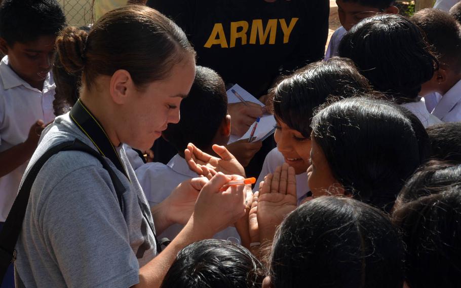 Army Staff Sgt. Monet Figueroa signs autographs on hands, notebooks and anything alse the children request at a school on Sri Lanka's rural south coast during the Pacific Partnership 2017 exercise, March 7, 2017.