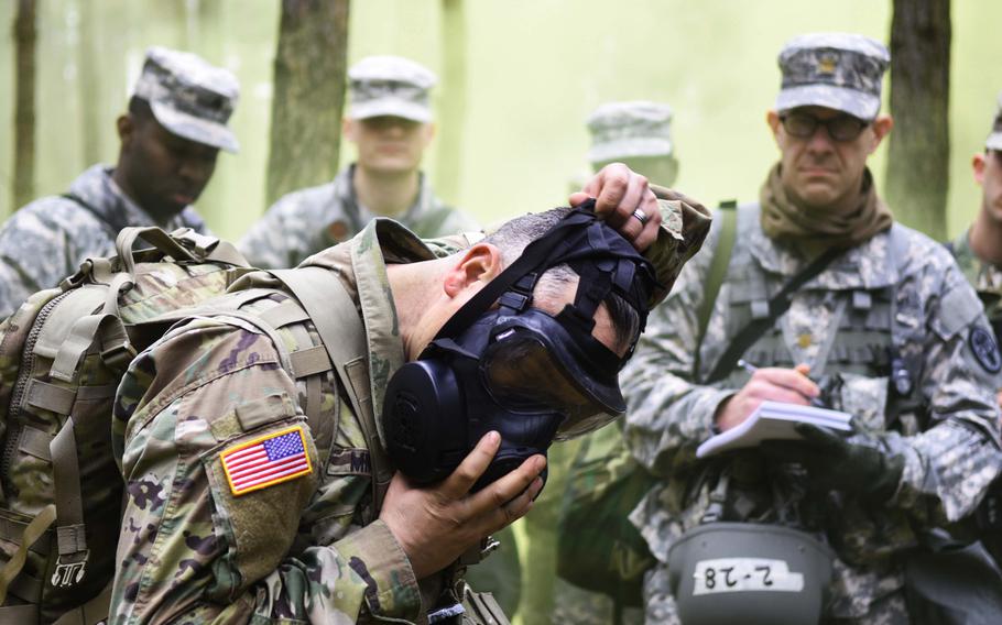 An instructor dons a gas mask during the Expert Field Medical Badge training at Grafenwoehr, Germany, on Monday, March 20, 2017. During the training, candidates from 11 nations had to perform 13 tasks ranging from chemical warfare defense to medical evacuation drills, in order to earn one of the most sought after badges in the U.S. Army.
