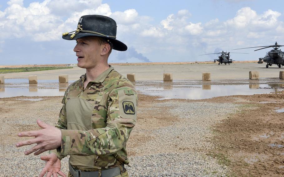 Army Capt. Lucas Gebhart of Laconia, N.H., speaks with reporters at Qayara Airfield West, Iraq, near some of the Apaches from Bravo Troop of the 4th Squadron, 6th Cavalry, which he commands and which are detached to the base to support Iraqi troops fighting in western Mosul.