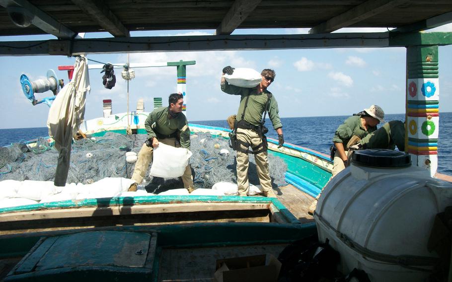 Sailors assigned to the USS Laboon offload bags containing hashish from a dhow in the Arabian Sea, Friday, March 17, 2017.
