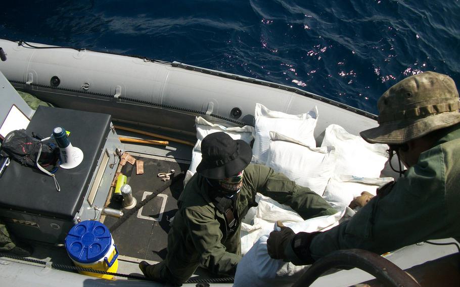 Sailors assigned to the USS Laboon offload bags containing hashish from a dhow in the Arabian Sea, Friday, March 17, 2017. Laboon sailors intercepted the dhow and seized 500 kg of hashish, their second successful drug interdiction operation in five days.