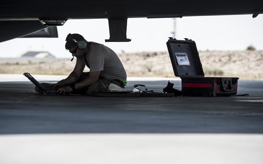 A maintainer for the 5th Expeditionary Air Mobility Squadron checks instructions before putting a cover plate on the bottom of a C-17 Globemaster III in an undisclosed location in Southwest Asia on Tuesday, March 21, 2017.